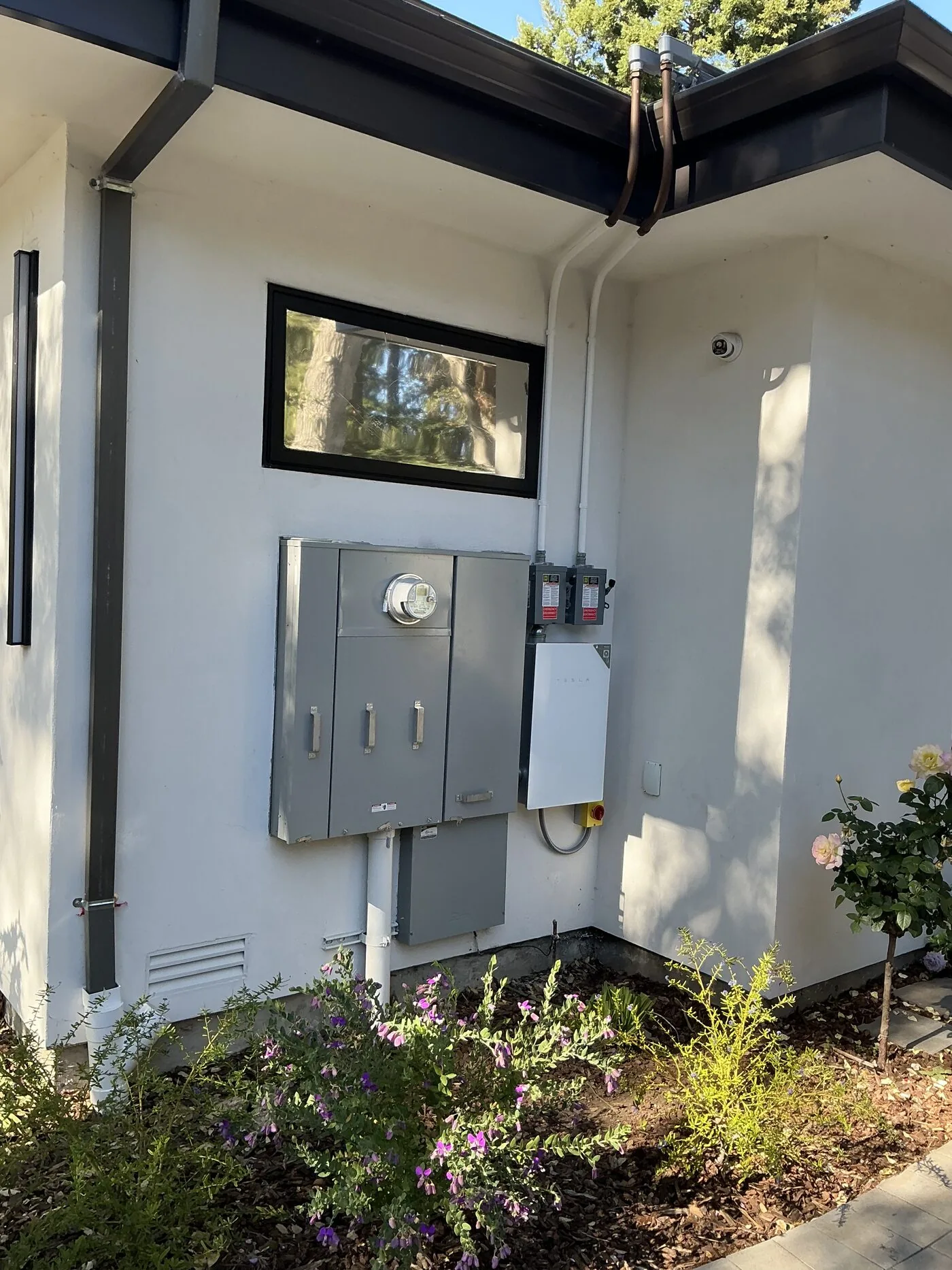 Main electrical panel, safety disconnects and a battery backup switch mounted on an exterior wall of a home